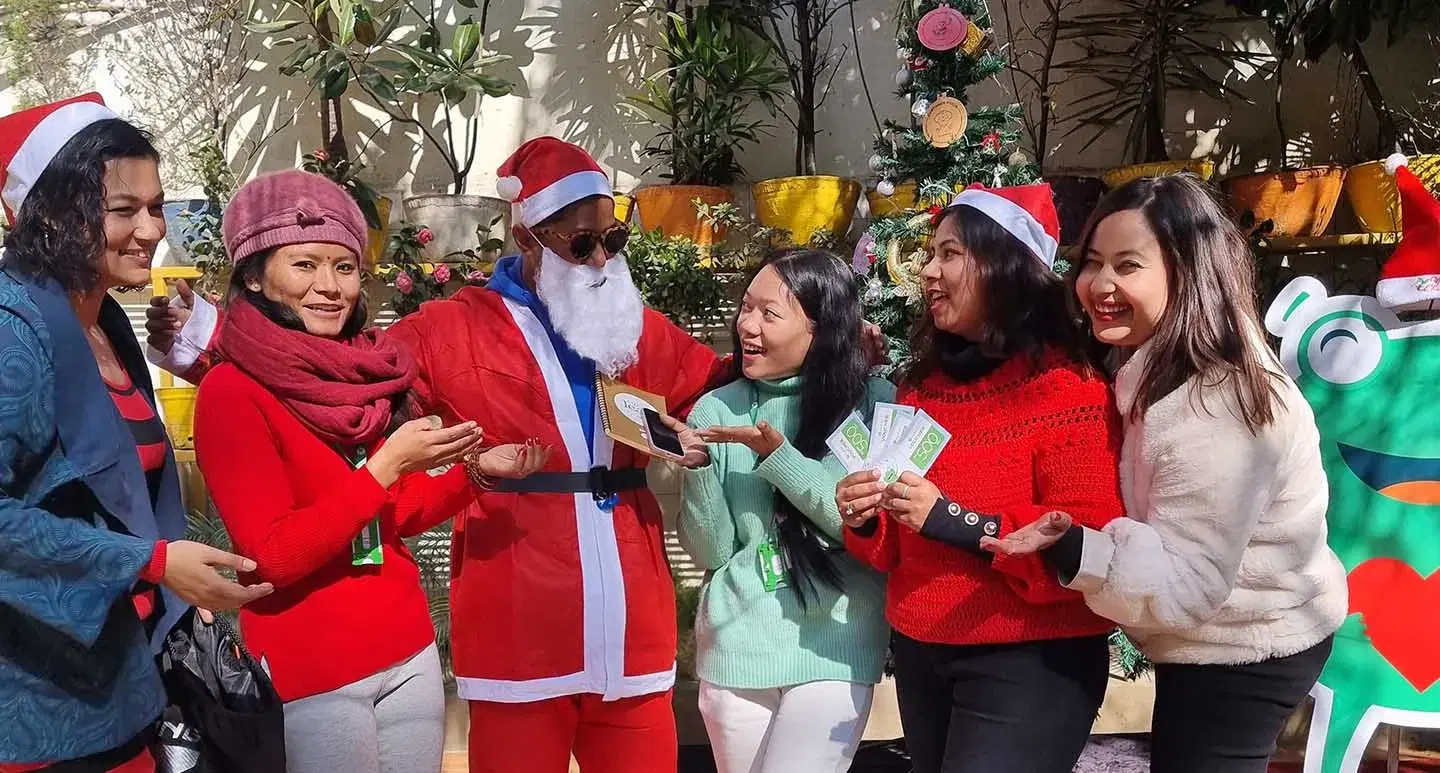 Santa Claus and five females celebrating Christmas with joyful smiles.