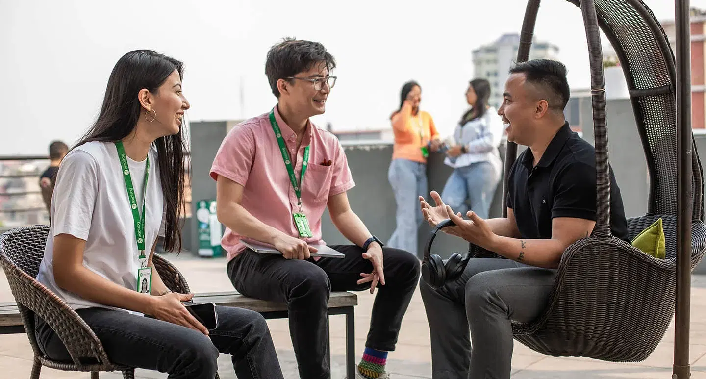 Three employees on a rooftop, enjoying breaks and sharing laughter.